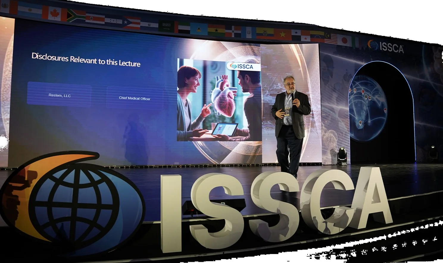 Speaker presenting on the ISSCA main stage under the international flag banner