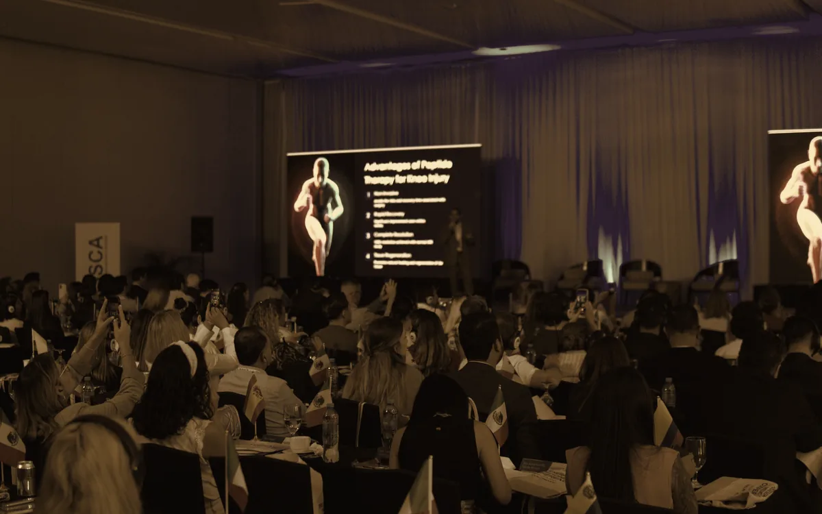 Un salón de congreso ISSCA lleno de médicos frente al escenario y las pantallas LED